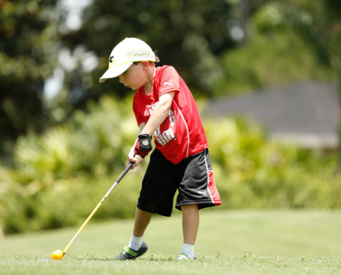 little kid hitting a golf ball